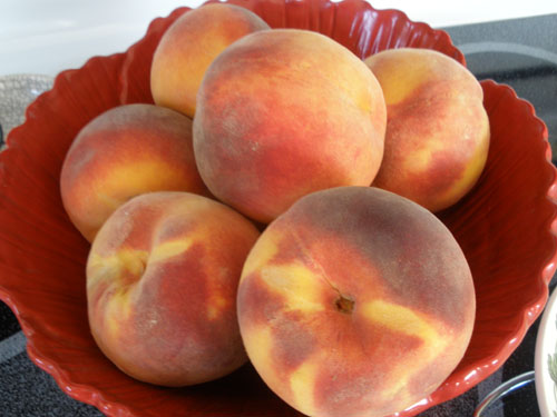 Ripe, Round Peaches in Red Bowl